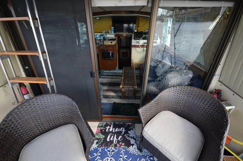 Slide: The Image of 1975 Bayliner Montego boat interior with wicker chairs and cozy living space. - 6