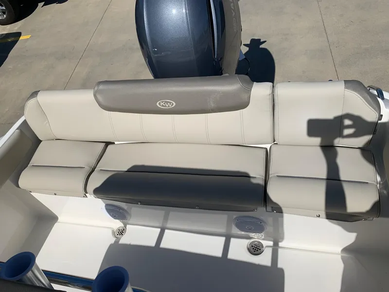 Slide: The Image of 2024 Key West 219 FS boat with cushioned seating and outboard motor. - 13
