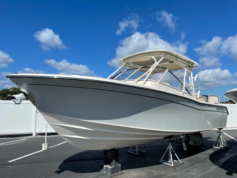 Slide: The Image of 2024 Grady-White Freedom 275 boat on display under a clear blue sky. - 1