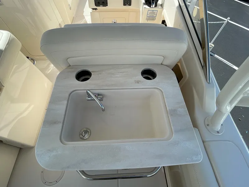Slide: The Image of Grady-White Freedom 275 2024 boat interior sink and cup holders. - 10