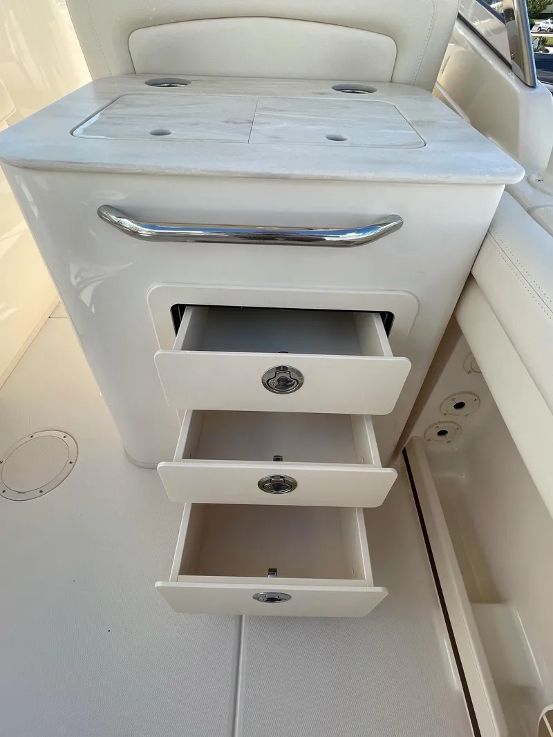 Slide: The Image of Grady-White Freedom 275 2024 boat interior with open storage drawers. - 11