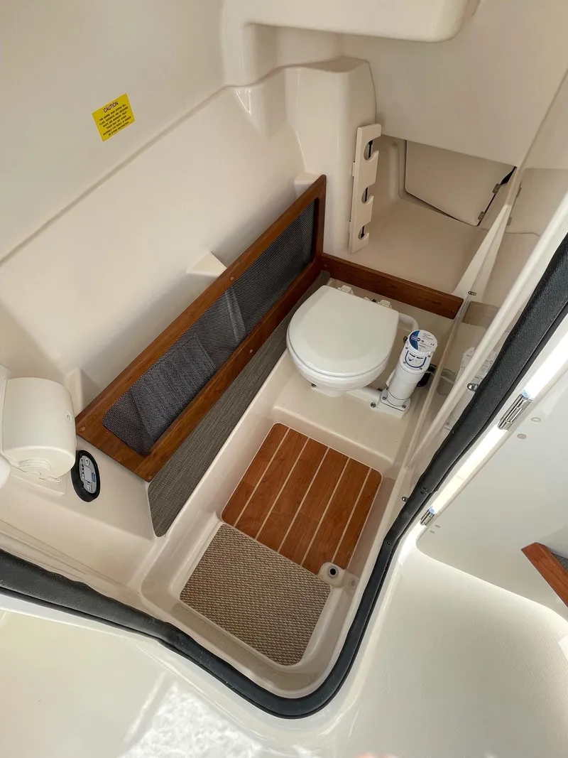 Slide: The Image of 2024 Grady-White Freedom 275 boat interior bathroom with toilet and wooden accents. - 4