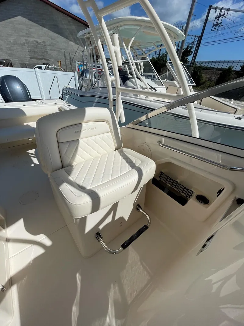 Slide: The Image of 2024 Grady-White Freedom 275 boat interior with white seating and helm station. - 5