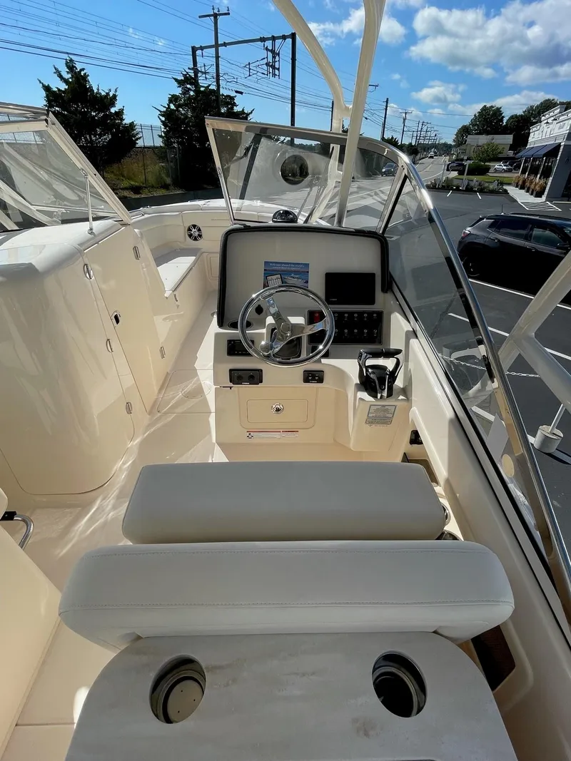 Slide: The Image of 2024 Grady-White Freedom 275 boat cockpit with steering wheel and control panel. - 7