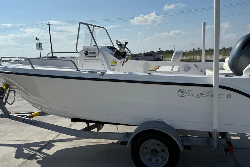 Slide: The Image of 2024 Edgewater 170CC boat on trailer, parked outdoors under a clear sky. - 13