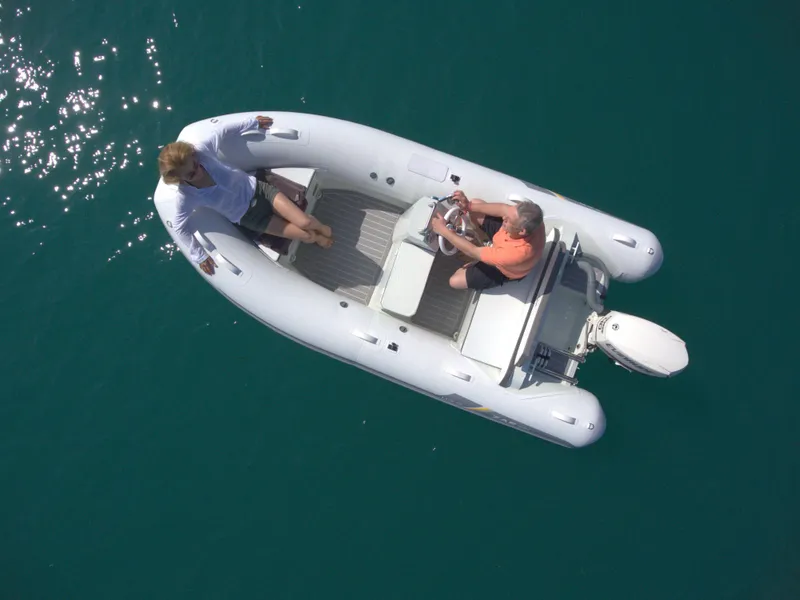 Slide: The Image of 2023 ZAR Mini LUX 13 inflatable boat on clear blue water. - 2