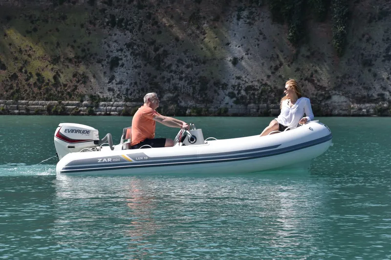 Slide: The Image of 2023 ZAR Mini LUX 13 inflatable boat on a serene lake with two people. - 5