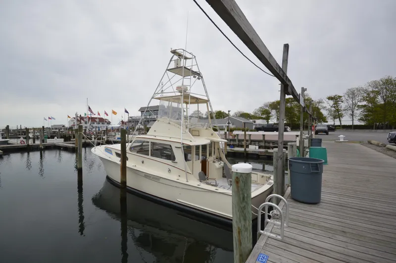 Slide: The Image of 1961 Hatteras 41 Convertible docked at a marina on a cloudy day. - 2