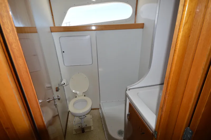 Slide: The Image of 1961 Hatteras 41 Convertible boat bathroom with toilet, shower, and sink. - 20