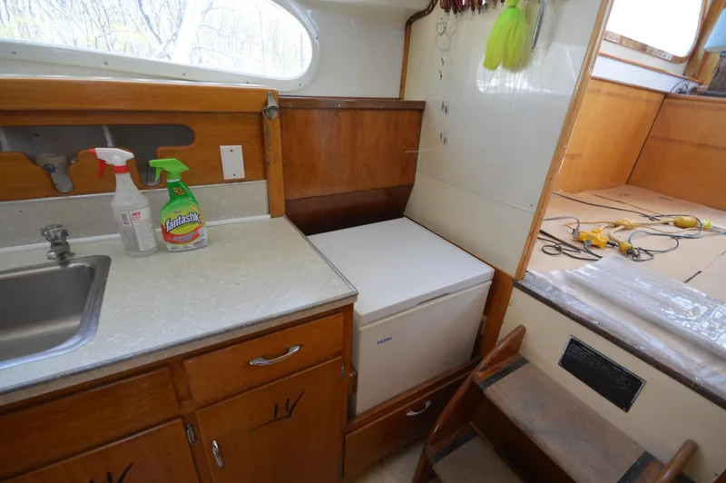 Slide: The Image of 1961 Hatteras 41 Convertible kitchen area with sink, counter, and storage. - 23