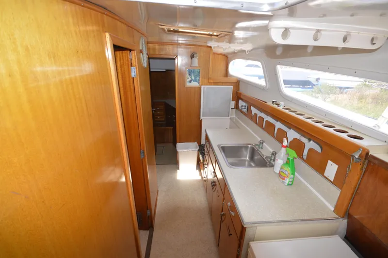 Slide: The Image of 1961 Hatteras 41 Convertible yacht interior kitchen with wooden cabinets and countertops. - 24