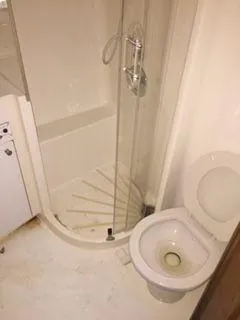 Slide: The Image of Bathroom interior of a 1996 Hatteras SPORTFISH EXPRESS yacht, featuring a shower and toilet. - 18