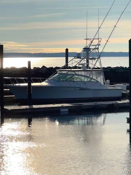 Slide: The Image of 1996 Hatteras SPORTFISH EXPRESS yacht docked at sunset, reflecting on calm water. - 28