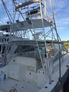 Slide: The Image of 1996 Hatteras SPORTFISH EXPRESS boat with tower, docked at marina under clear sky. - 4