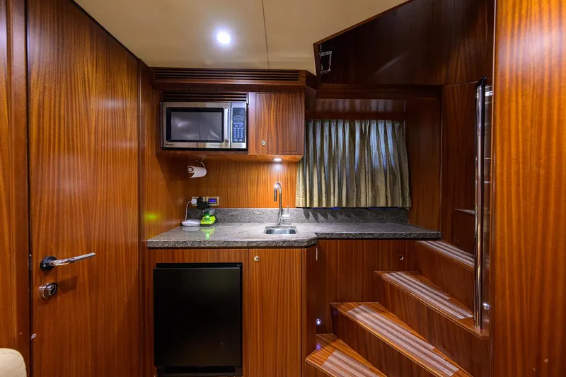Slide: The Image of Compact kitchen area in 2013 Ocean Alexander Sky Lounge yacht with wood finish and modern amenities. - 85