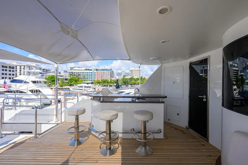 Slide: The Image of Luxurious 2013 Ocean Alexander Sky Lounge yacht deck with bar stools and marina view. - 49