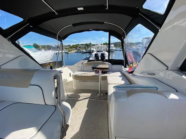 Slide: The Image of 2010 Sea Ray 310 Sundancer interior with seating, table, and marina view. - 11