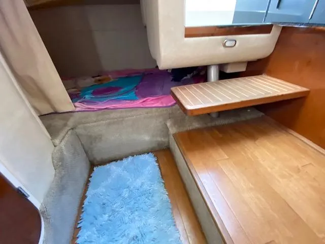 Slide: The Image of Interior cabin of 2010 Sea Ray 310 Sundancer with wooden steps and cozy sleeping area. - 14