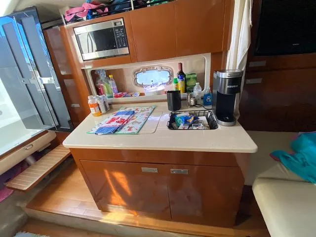 Slide: The Image of Interior of 2010 Sea Ray 310 Sundancer with kitchenette and modern amenities. - 16