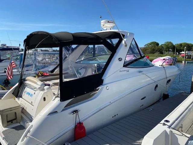 Slide: The Image of 2010 Sea Ray 310 Sundancer docked, featuring sleek design and black canopy. - 20