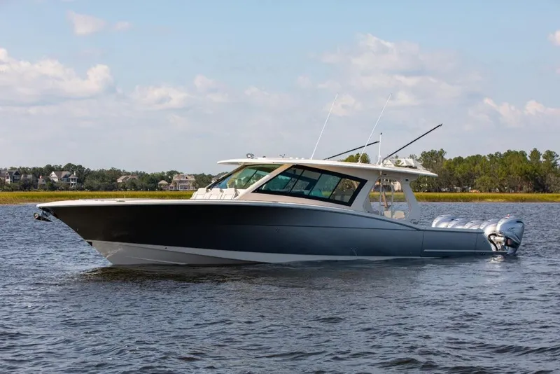 Slide: The Image of 2024 Scout 530 LXF luxury boat on calm water. - 2