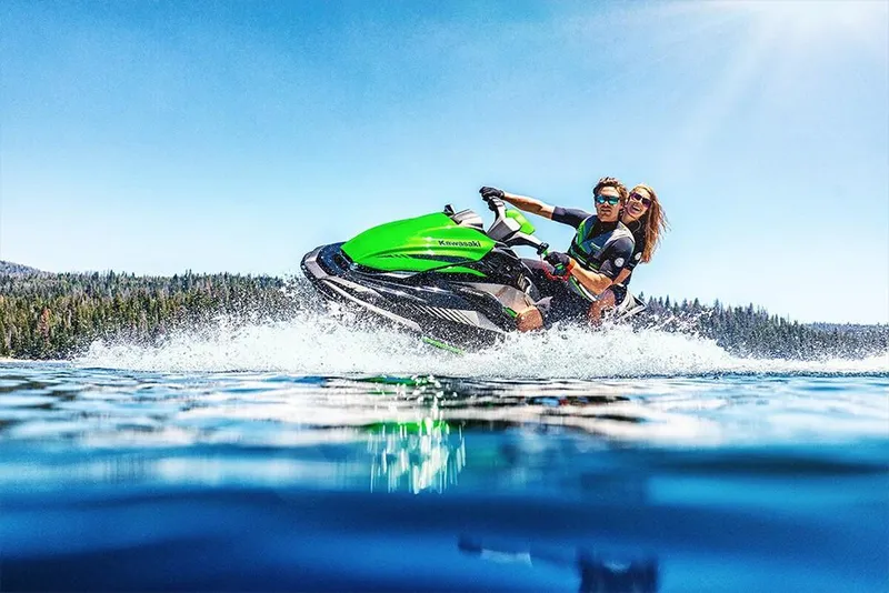 Slide: The Image of 2023 Kawasaki STX 160 jet ski on a lake with two riders. - 24