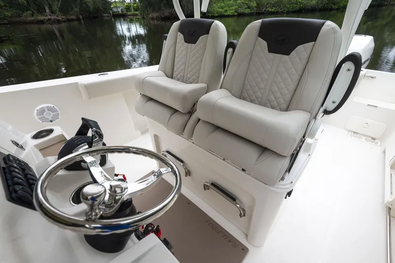 Slide: The Image of 2024 Sailfish 320 CC boat interior with dual captain's chairs and steering wheel. - 1