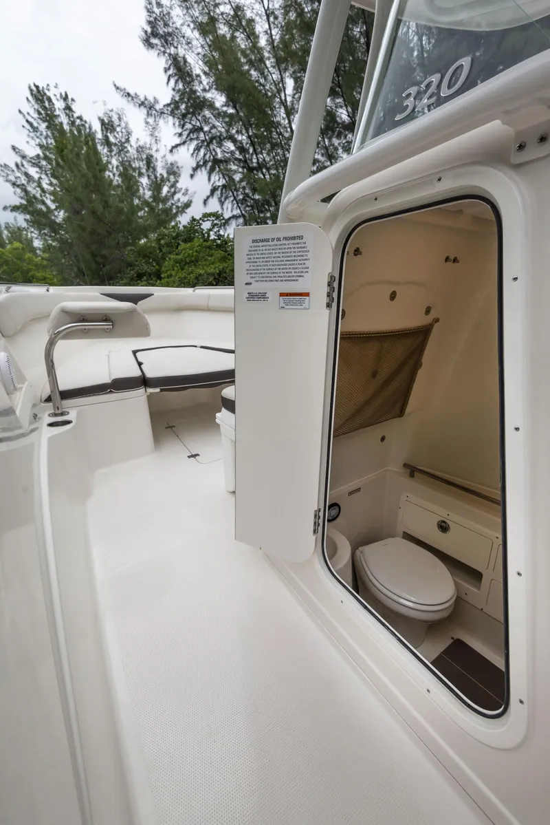 Slide: The Image of 2024 Sailfish 320 CC boat interior with open door to bathroom. - 15