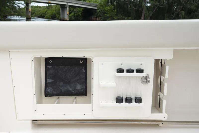 Slide: The Image of 2024 Sailfish 320 CC boat storage compartments and fishing rod holders. - 20