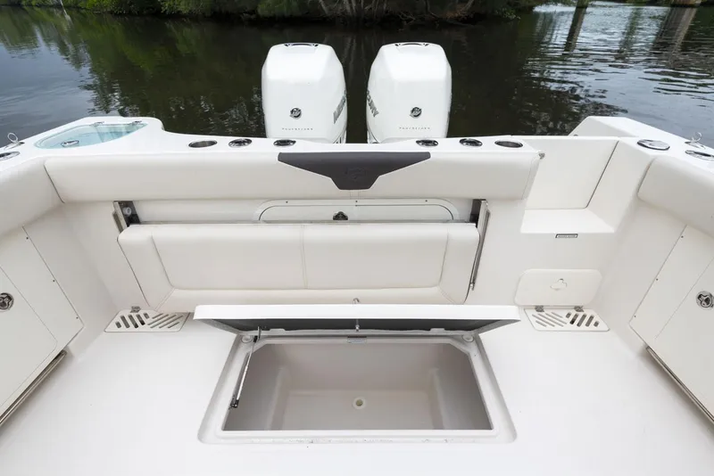 Slide: The Image of 2024 Sailfish 320 CC boat with open storage compartment and twin outboard motors. - 21