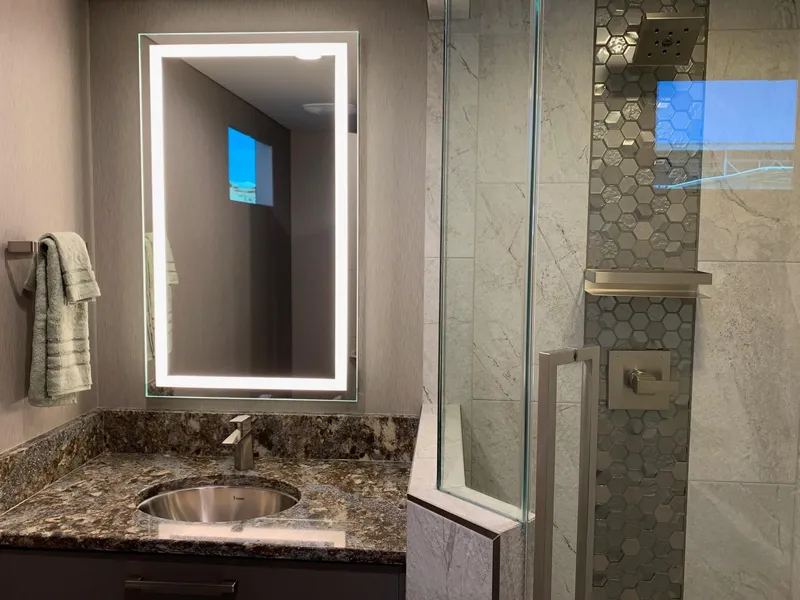 Slide: The Image of Modern bathroom with illuminated mirror, granite countertop, and glass shower in Adonia Harmony Share 2, 2020. - 10