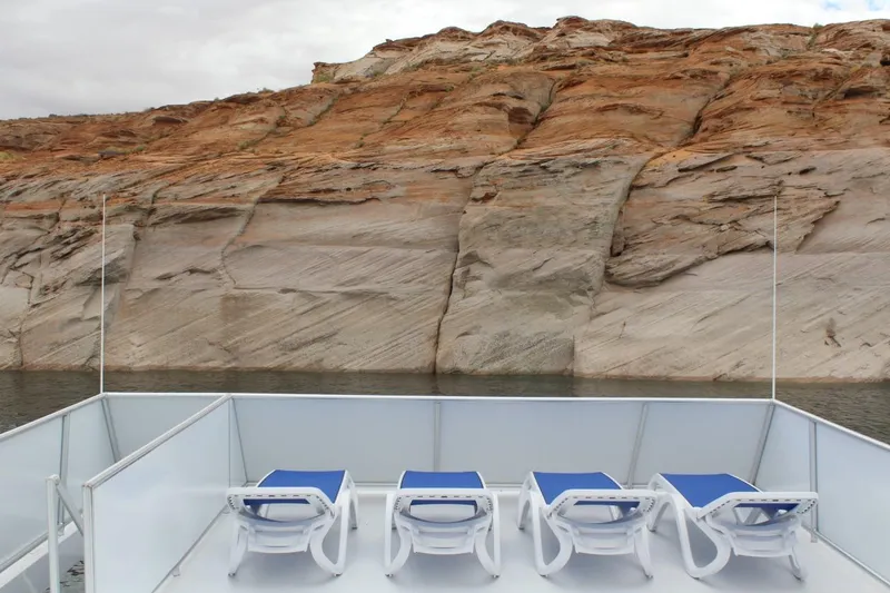 Slide: The Image of Sun loungers on Adonia Harmony Share 2 boat deck, overlooking rocky cliffs and calm waters. - 27