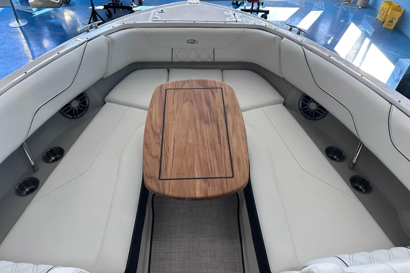 Slide: The Image of 2026 Regal LX6 boat interior with white seating and wooden table. - 26