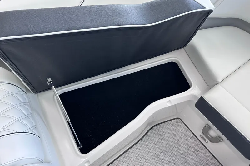 Slide: The Image of 2026 Regal LX6 boat storage compartment with open seat cushion, showcasing spacious interior. - 28