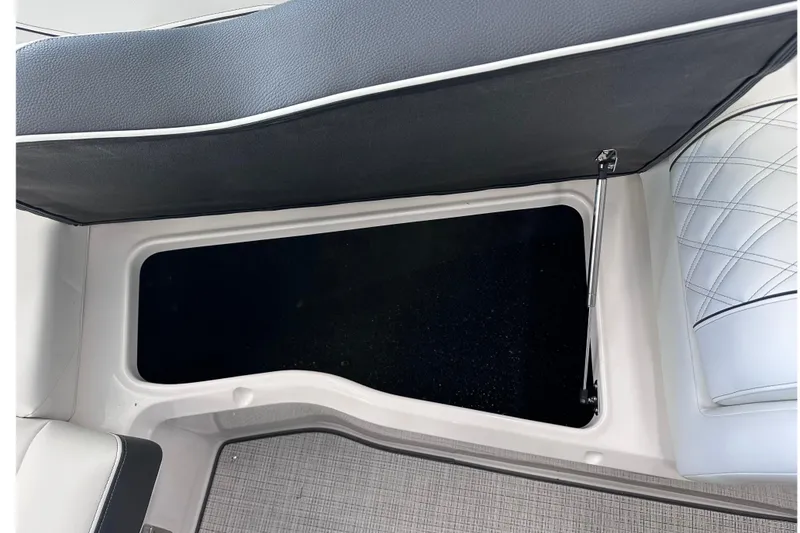 Slide: The Image of 2026 Regal LX6 boat storage compartment with cushioned seating and hydraulic lift. - 32