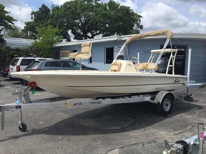 The Image of 2025 Scout 177 Sport boat on a trailer in a dealership parking lot. - 0