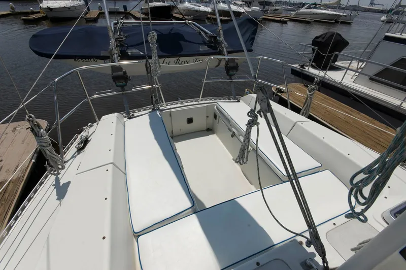 Slide: The Image of 1984 Jouet 1280 sailboat cockpit with white cushions docked at marina. - 11