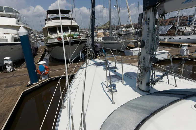Slide: The Image of Sailboat Jouet 1280 (1984) docked at a marina with other boats. - 12