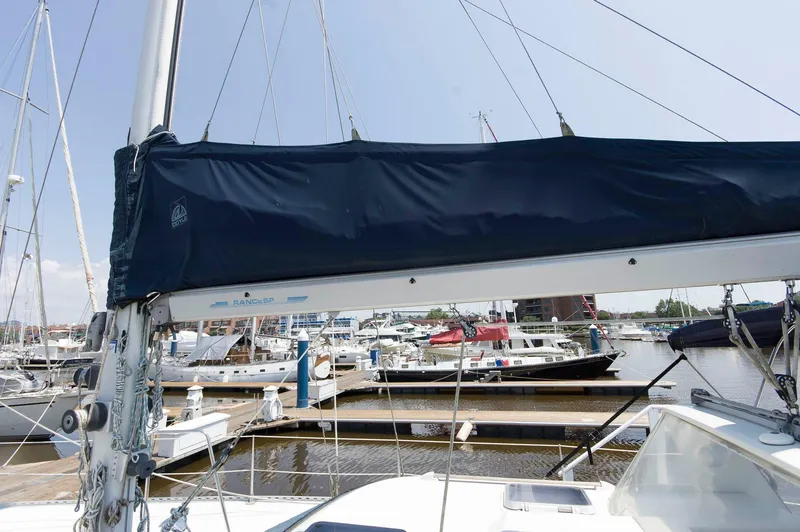 Slide: The Image of Sailboat Jouet 1280 (1984) docked at a marina with other boats in the background. - 15