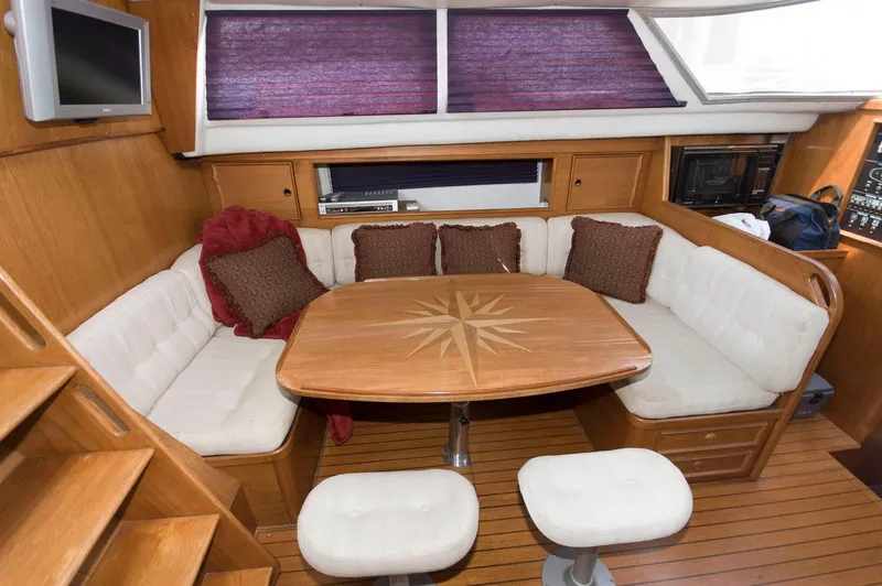 Slide: The Image of Cozy dining area in a 1984 Jouet 1280 sailboat with cushioned seating and wooden table. - 20