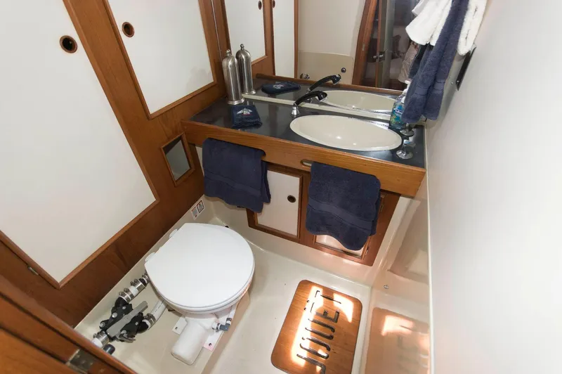 Slide: The Image of 1984 Jouet 1280 yacht bathroom with sink, toilet, and wooden cabinetry. - 28