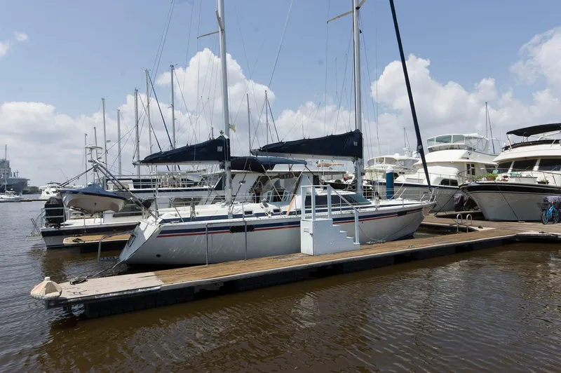 Slide: The Image of Sailboats docked at marina, featuring a 1984 Jouet 1280 model. - 3