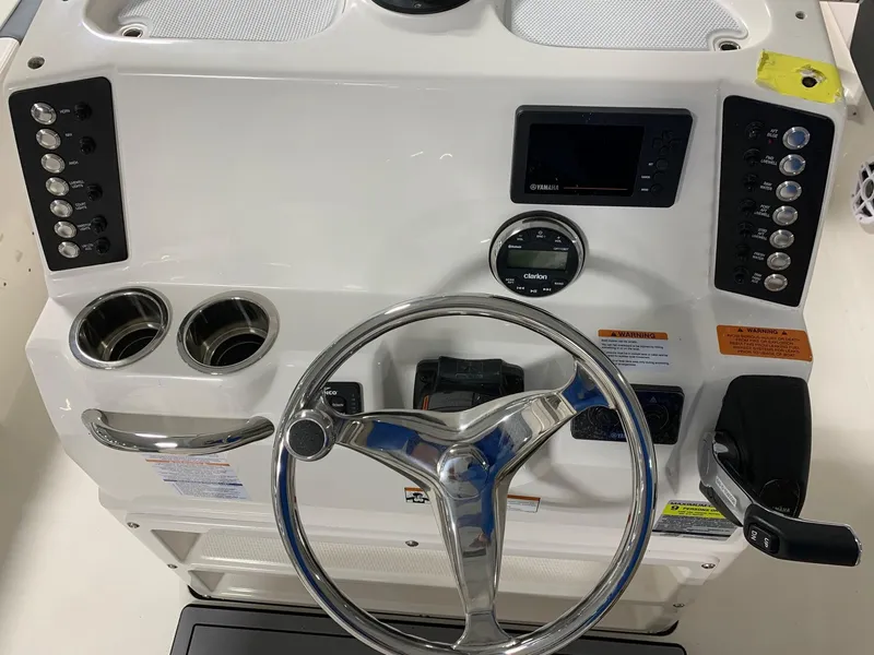 Slide: The Image of 2024 Robalo 246 Cayman boat dashboard with steering wheel and control panel. - 10