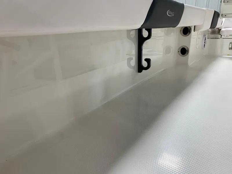 Slide: The Image of 2024 Robalo 246 Cayman boat interior, white deck with black hooks. - 17