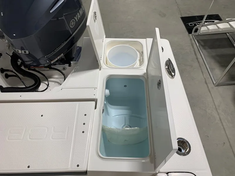 Slide: The Image of 2024 Robalo 246 Cayman boat with open storage compartments and Yamaha outboard motor. - 19