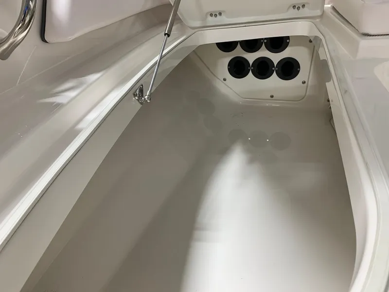 Slide: The Image of 2024 Robalo 246 Cayman storage compartment with rod holders. - 24