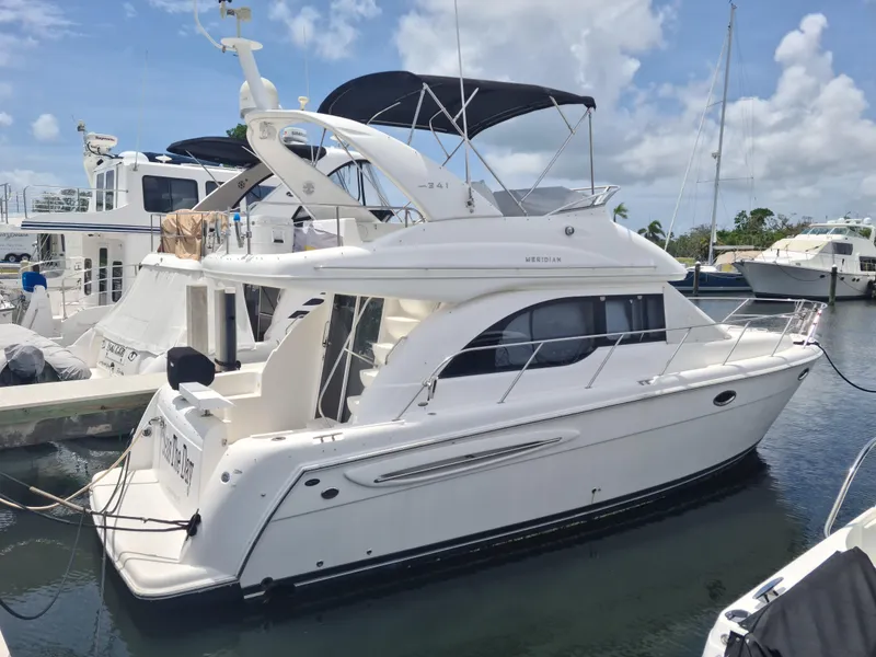 Slide: The Image of 2004 Meridian 341 Sedan yacht docked at marina under clear blue sky. - 1