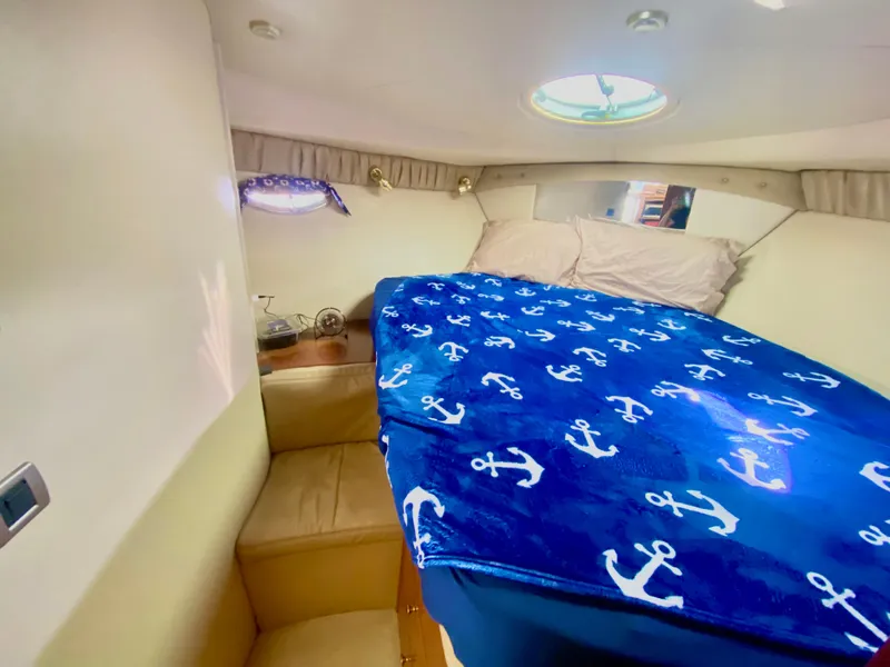 Slide: The Image of Cozy bedroom in 2004 Meridian 341 Sedan with nautical-themed bedding and porthole window. - 21