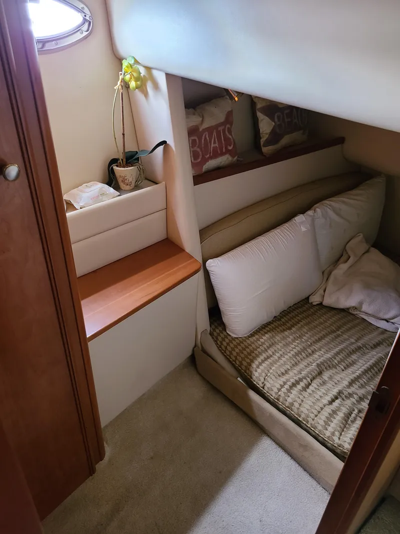 Slide: The Image of Cozy cabin interior of 2004 Meridian 341 Sedan with bed and decorative pillows. - 24