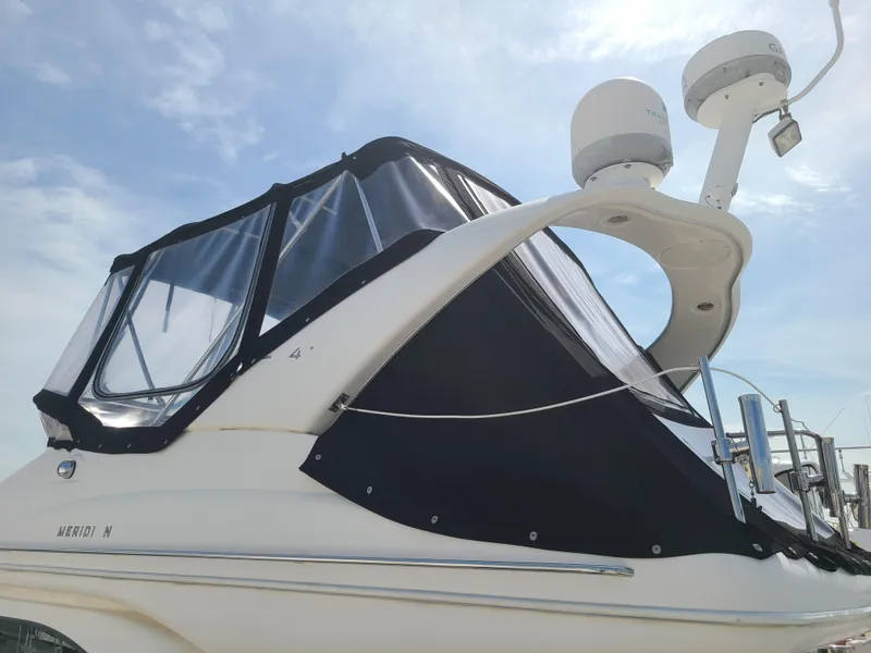 Slide: The Image of 2004 Meridian 341 Sedan boat with black canopy and radar equipment under a clear sky. - 5